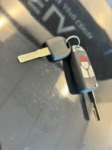 car key and key fob placed on vehicle surface for automotive locksmith key replacement service