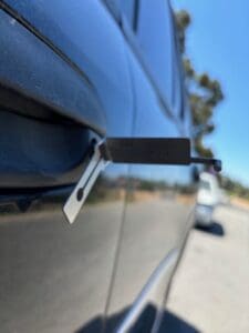 locksmith tool inserted in car door for vehicle lockout unlocking service