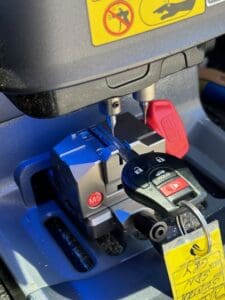 car key cutting machine duplicating key during automotive locksmith service