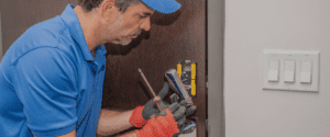 professional locksmith repairing door lock with tools for residential security service