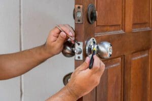 locksmith repairing and rekeying door lock using tools for home security service